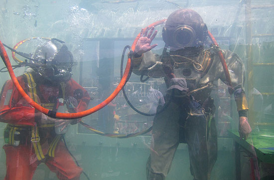 Divers in tank with old and new equipment