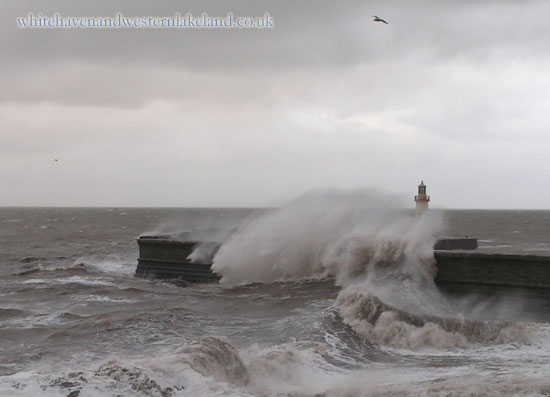 waves crashing over west pier