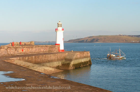 a fishing boat passing Whitehaven's west pier