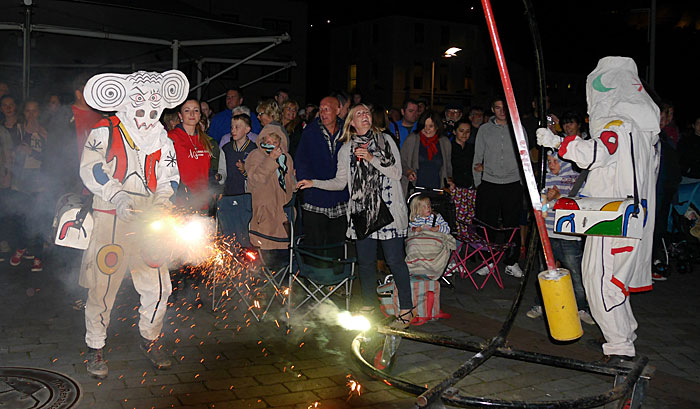 excited crowd surround firework performers