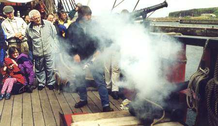 A cannon being fired on-board Grand Turk